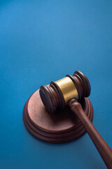 Judge gavel with sound block on blue background. Represents courtroom authority and legal...
