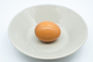 Boiled eggs in a circular bowl on a white background