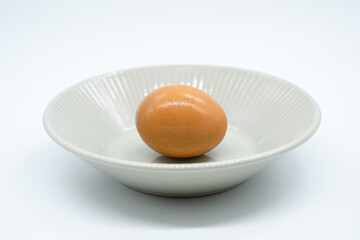 Boiled eggs in a circular bowl on a white background