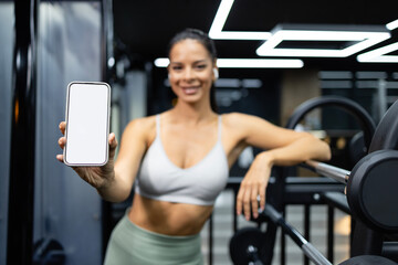 Professional fitness instructor showing smart phone white display.
