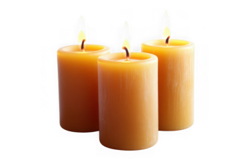 Three lit pillar candles with yellow flames on black background fire
