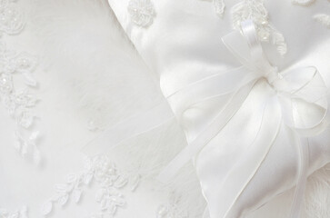 White wedding satin pillow on a white lace