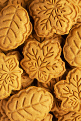 Close-up of honey or gingerbread cookies shaped like autumn leaves. Maple and oak leaves made from shortcrust pastry. Autumn baking