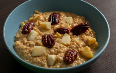 delicious oatmeal with pumpkin apple and pecans close up
