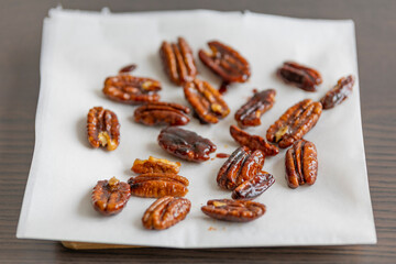caramelized pecans on white background close up