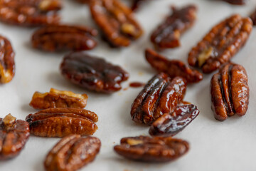 caramelized pecans on white background close up