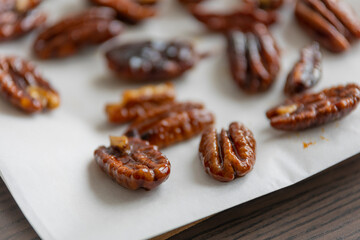 caramelized pecans on white background close up