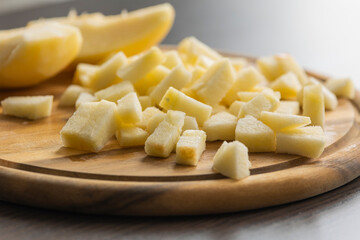 chopping fresh crisp apple on wooden cutting board close up