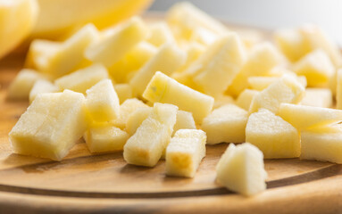chopping fresh crisp apple on wooden cutting board close up