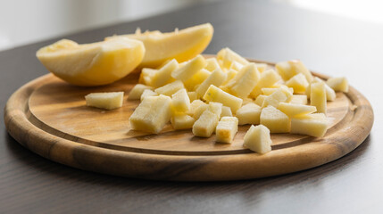 chopping fresh crisp apple on wooden cutting board close up