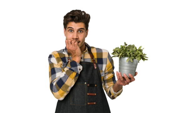 Young caucasian gardener man isolated on white background biting fingernails, nervous and very anxious.