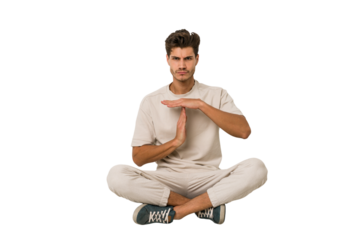 Young caucasian man sitting on the floor isolated on white background showing a timeout gesture.