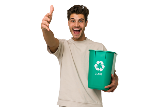 Young caucasian man holding a glass trash isolated receiving a pleasant surprise, excited and raising hands.