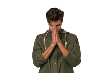 Young handsome caucasian man isolated on white background praying, showing devotion, religious person looking for divine inspiration.
