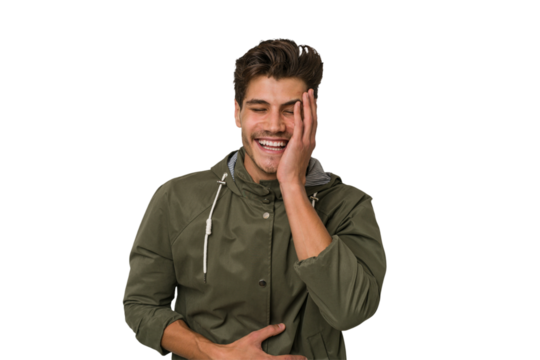 Young handsome caucasian man isolated on white background laughs happily and has fun keeping hands on stomach.