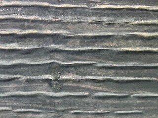 Wooden boards and horizontal wave like swelling formed by rain or moisture over time. Rough surface with grain distortion and texture depth, creating an aged and organic appearance.