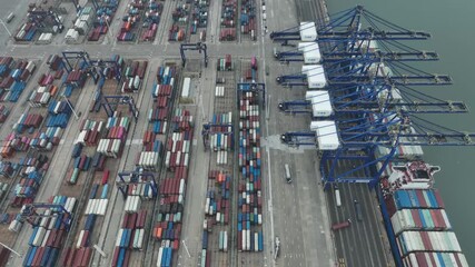 Xiamen, China - 17 September 2025: Aerial view of a port bustling with activity, featuring colorful shipping containers and towering cranes along the waterfront.