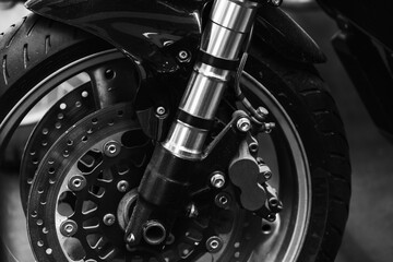 Detailed black-and-white close-up of a motorcycle front wheel with a disc brake