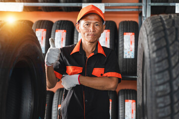 Professional tire shop worker giving a thumbs up in a tire storage area, showcasing expertise and readiness in vehicle maintenance and customer service