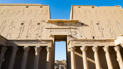 The entrance gate viewed from the internal courtyard of the famous temple of Edfu, Egypt, dedicated to the god Horus. With various decorations and hieroglyphics on the walls.