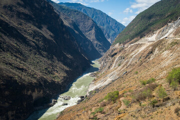 Aerial view of Tiger Leaping Gorge in Yunnan, China. The Jinsha River winding between steep cliffs of Haba and Jade Dragon Snow Mountains, one of the world’s deepest canyons