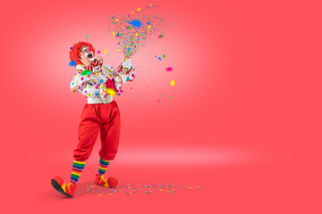 Funny clown pulling carnival cracker. Entertainer Joker in colorful suit and wig.Trickster, jester, pantomime, mime whiteface makeup. Professional actor at event, kids party, circus.