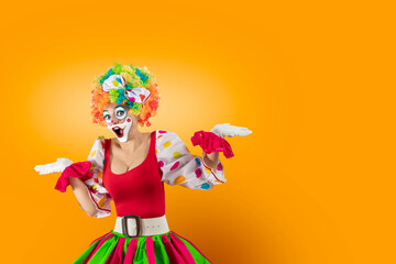 Confused female clown shrugging shoulders in bewilderment, doubting and feeling uncertain, don't know the answer. Woman entertainer as Joker in a suit and wig, with clown whiteface makeup