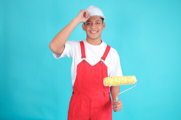 Smiling Asian Young Painter in Red Overalls Holding Brush Roller Ready to Repair in Room