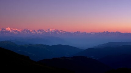 Fototapeta premium Serene sunset over majestic snow capped mountains with vibrant pink and purple sky creating a peaceful reflective atmosp