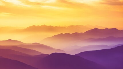 Obraz premium A vast mountain landscape with silhouetted peaks bathed in soft orange and purple hues, shrouded in morning mist,