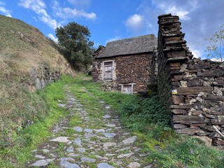 Casa de piedra y pizarra en el camino