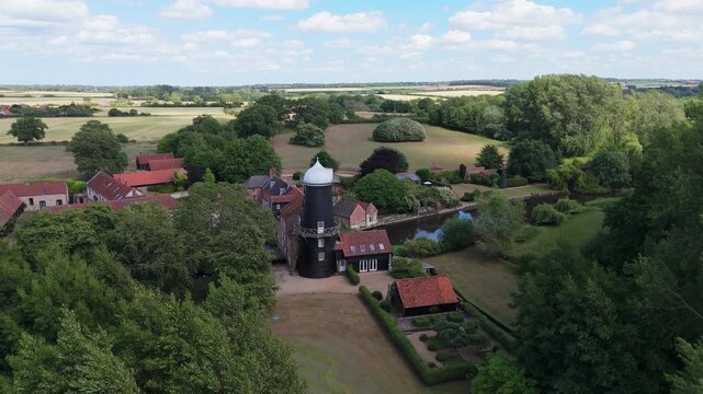 Ariel footage of Burnham Overy Staithe Mill in Norfolk England on the river Burn. Overy Water Mill, Windmill. Rural summer scene.