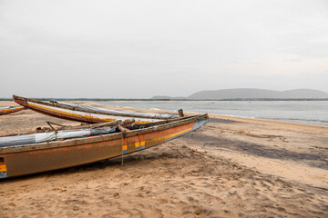 Obraz premium Motor boat moored at the sea shore. Traditional fishing boats and the beach landscape.