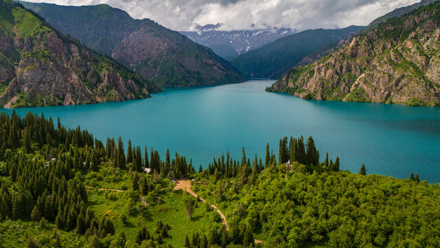 Aerial view of Sary-Chelek Lake in Kyrgyzstan. Deep blue alpine water surrounded by forested mountains and golden valleys within a pristine biosphere reserve