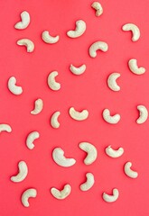 Top View of Cashew Nuts Scattered Isolated on Red Background with Copy Space in Vertical Orientation, Healthy Eating Dry Fruit