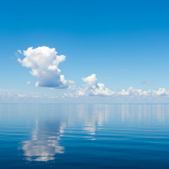 Serene Blue Ocean Reflecting Sky with Soft Clouds on a Calm Summer Day. 