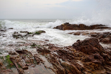 Old rocks on the seaside. Beautiful background of beach water flowing on the rocks.