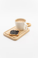 Tazza con bevanda d'orzo e fetta biscottatta con confettura di mirtilli su tagliere in legno su fondo bianco