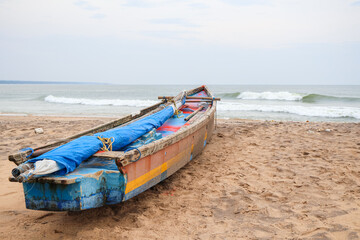 Obraz premium Motor boat moored at the sea shore. Traditional fishing boats and the beach landscape.