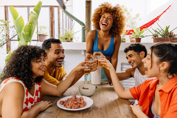 Friends toasting with beer and petiscos at barbecue table