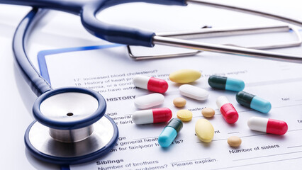 Medical healthcare concept showing a stethoscope resting on a patient's clinical chart with a...