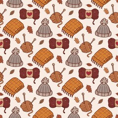 Warm knitting seamless pattern with yarn balls, wool hat and scarf, cozy handmade autumn illustration