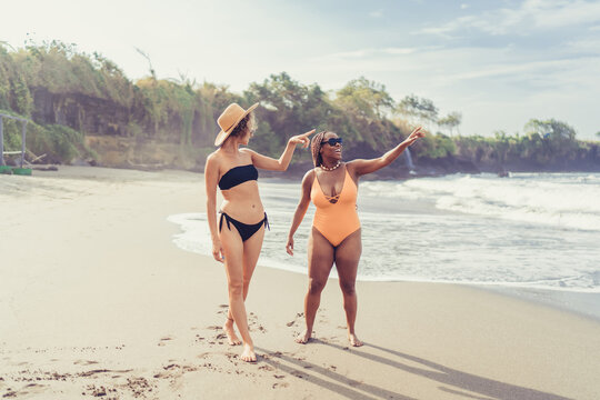 Diverse friends point joyfully toward sea horizon, capturing curiosity, shared vision and unplugged exploration on a digital-free beach journey rich in mindfulness and connection.