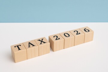 Wooden blocks spelling tax 2026 against blue background