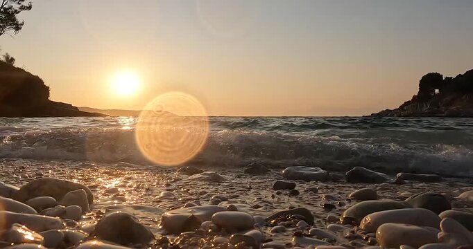 Golden sunset over rocky shore with calm waves and serene horizon