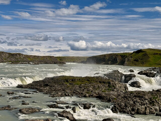 icelandic fast flowing thjorsa river cascading over basalt boulders at urridafoss on a sunny day