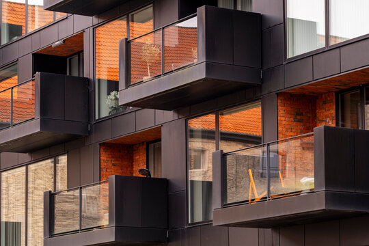 Modern apartments with protruding metal balconies and warm brick tones creating rhythm, depth and urban sophistication in Copenhagen contemporary design