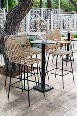 Outdoor seating area with stylish bar stools near a tree in a sunny location