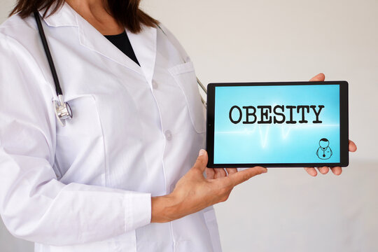 obesity. health and medicine concepts. female doctor with the word written on a digital tablet