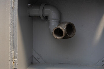 Pipes connecting inside a gray utility box with a smooth finish near a construction site